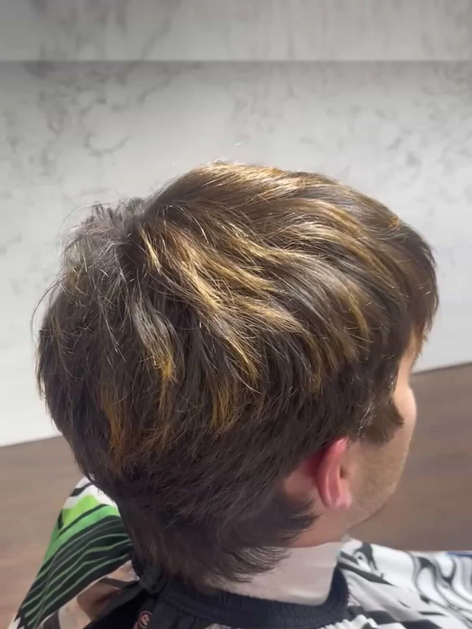 Before: grown-out, heavy hair with brassy leftover highlights and no shape at the nape.
