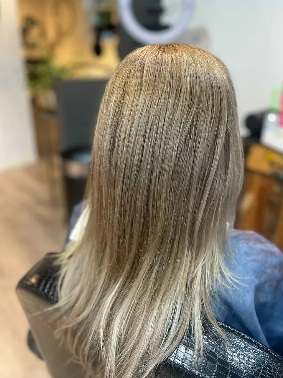 After: a sleek, glossed blonde with brightened, blended ends.