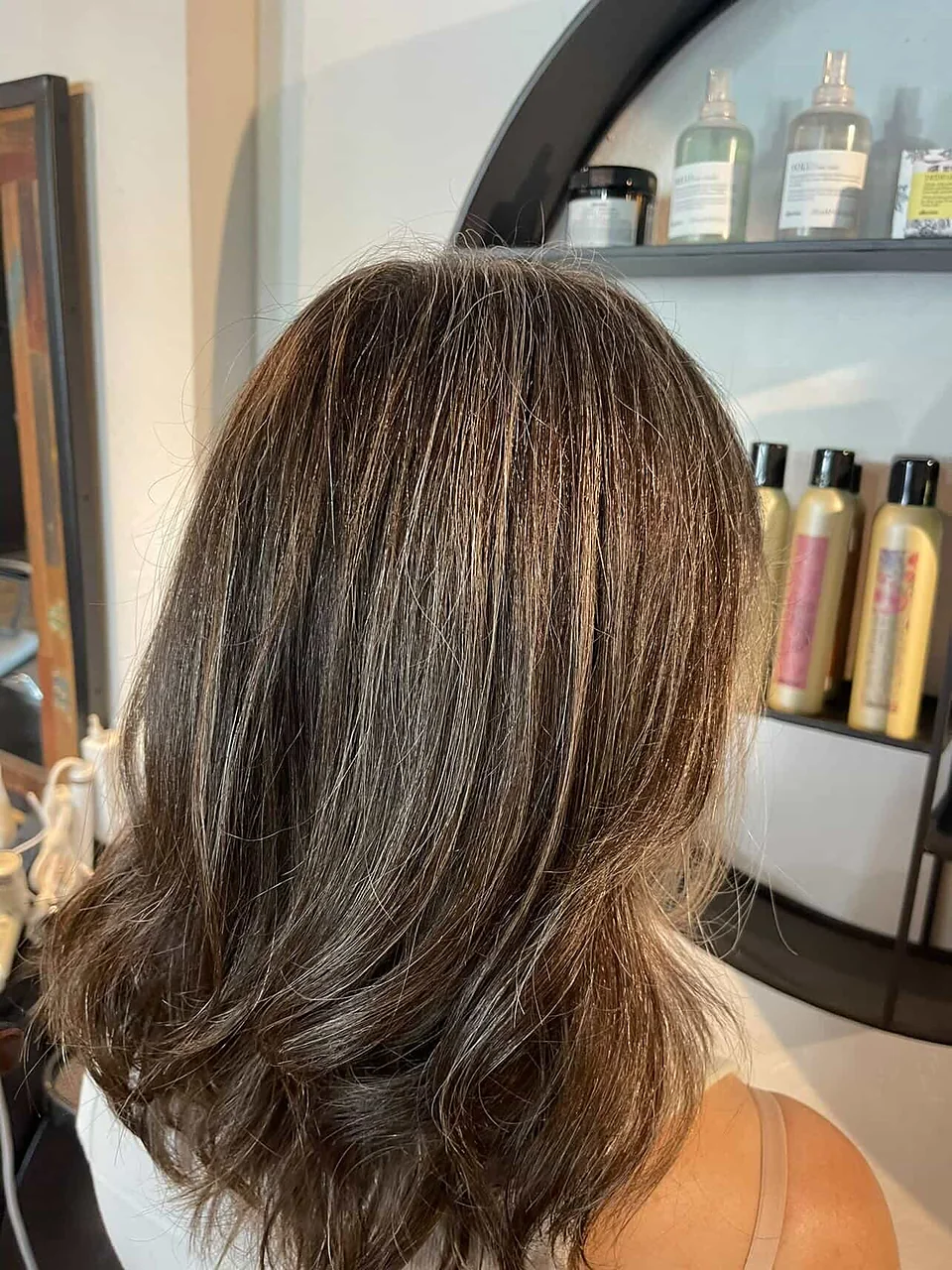 After: grey blended into soft, dimensional brunette with a styled bend.