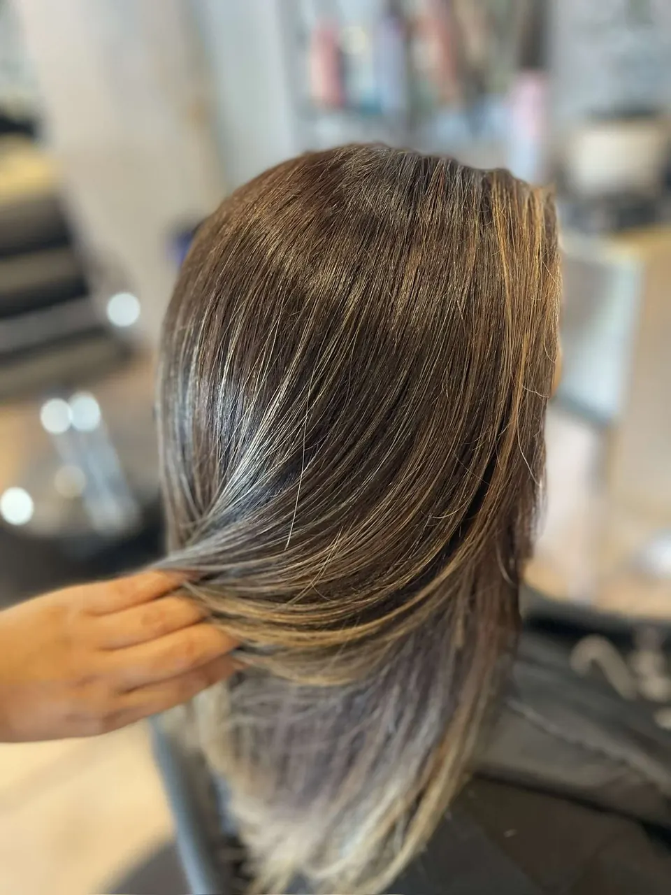 A brunette-to-bronde blend held out to show the ash tones through the mid-lengths.
