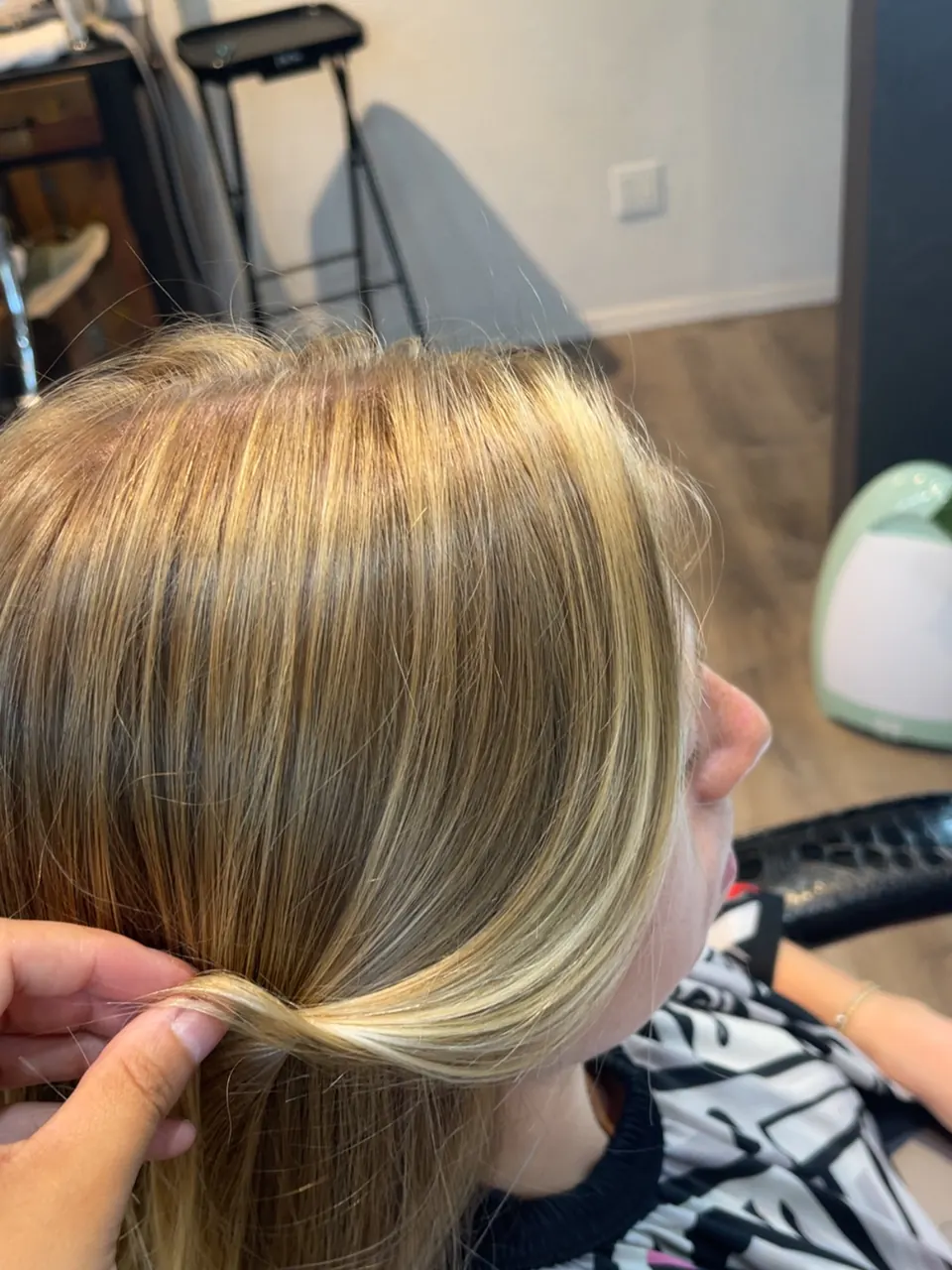A section of bright blonde foil work lifted to show the placement.