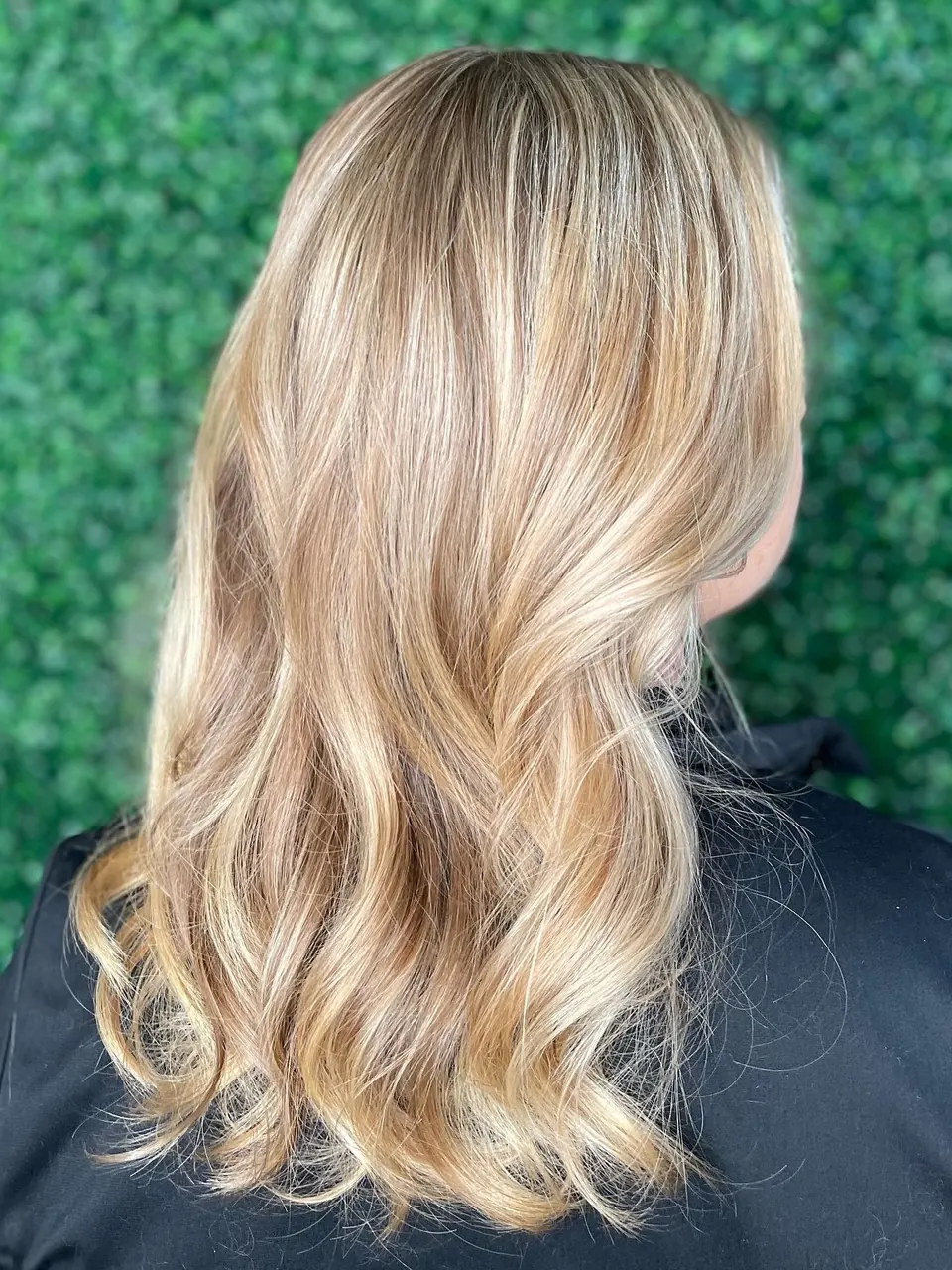 Bright blonde balayage with soft waves through the ends.