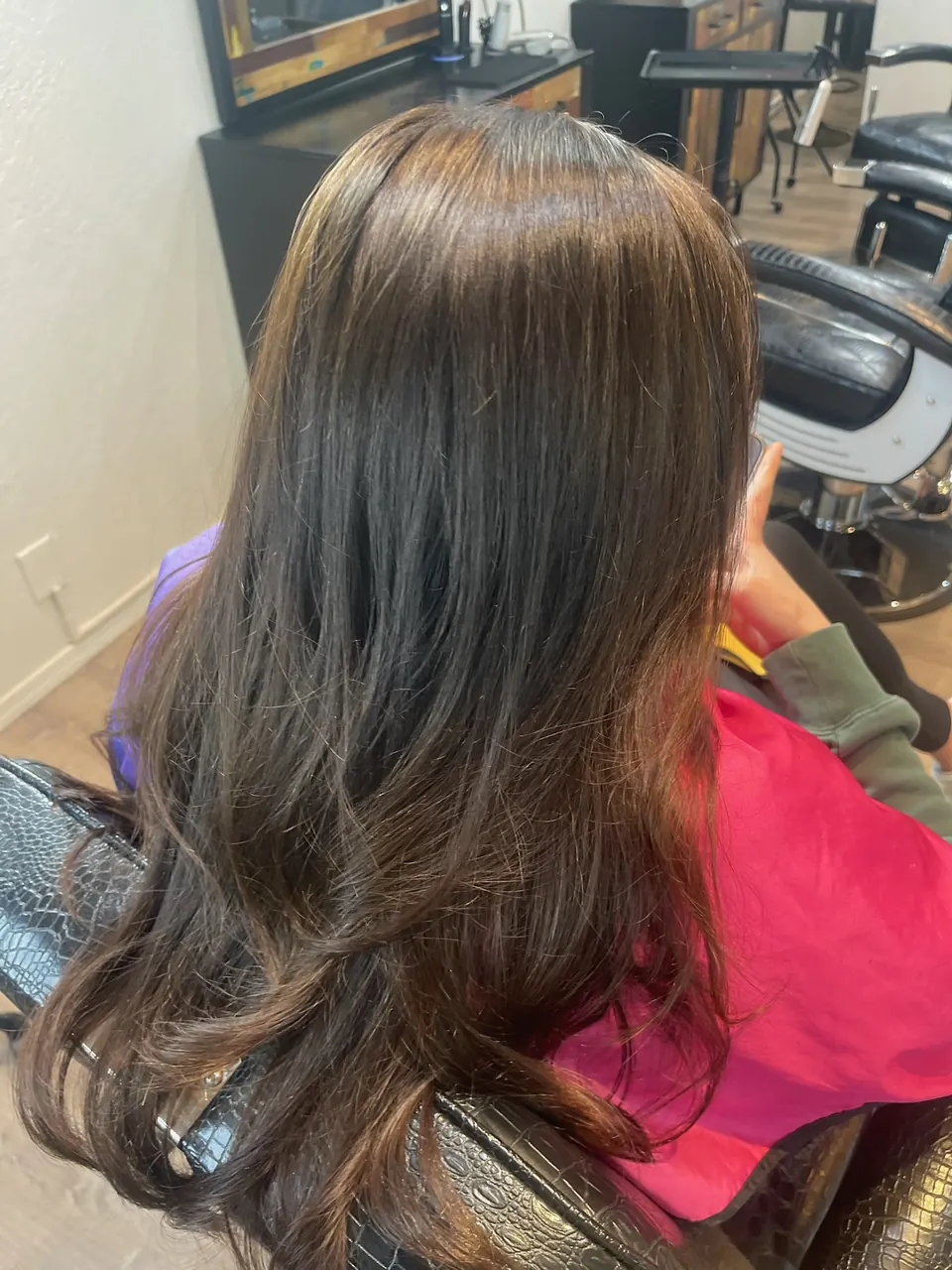 A long brunette blowout with curl through the ends.