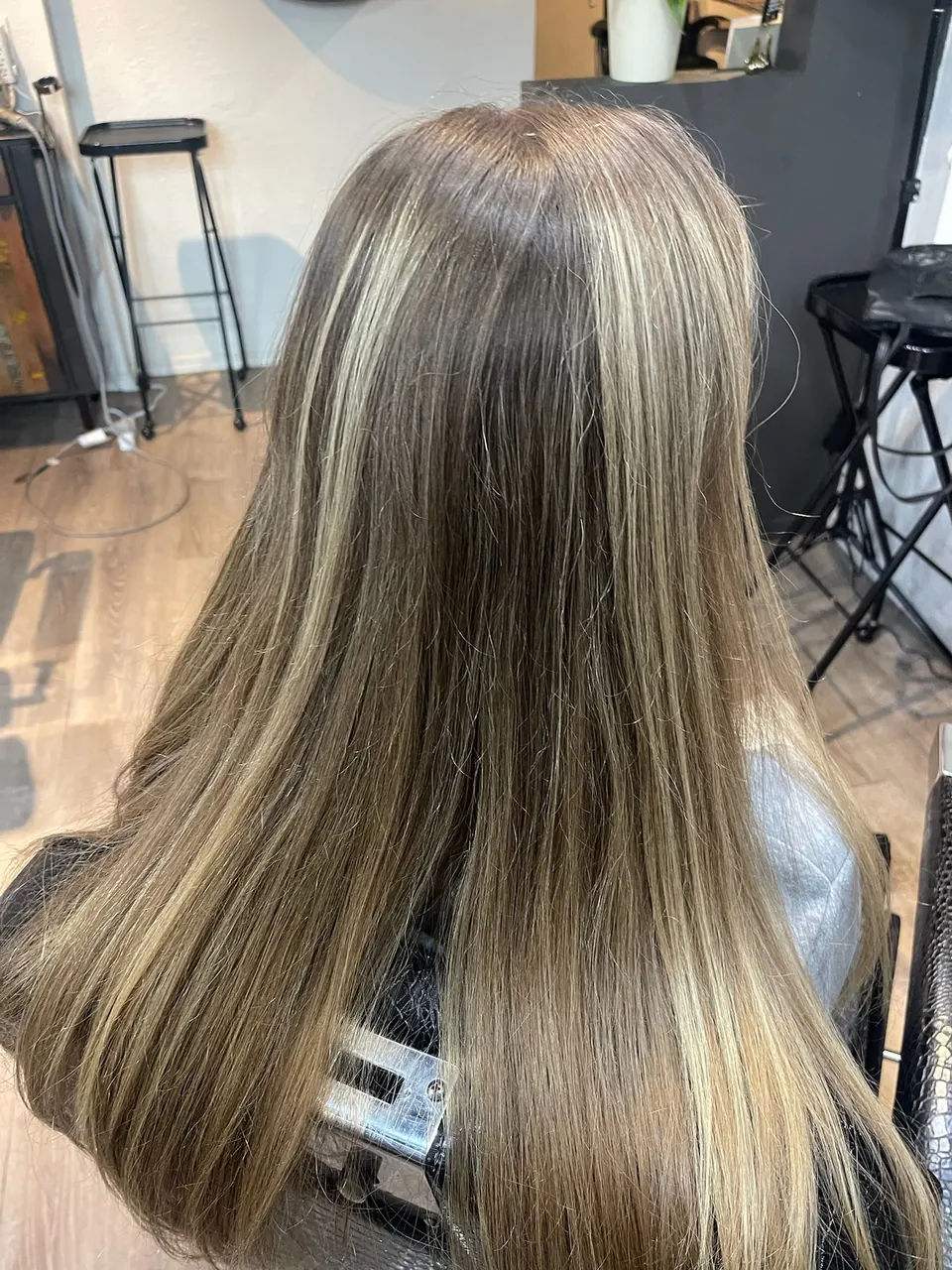 Dimensional blonde foils running the length of straightened hair.