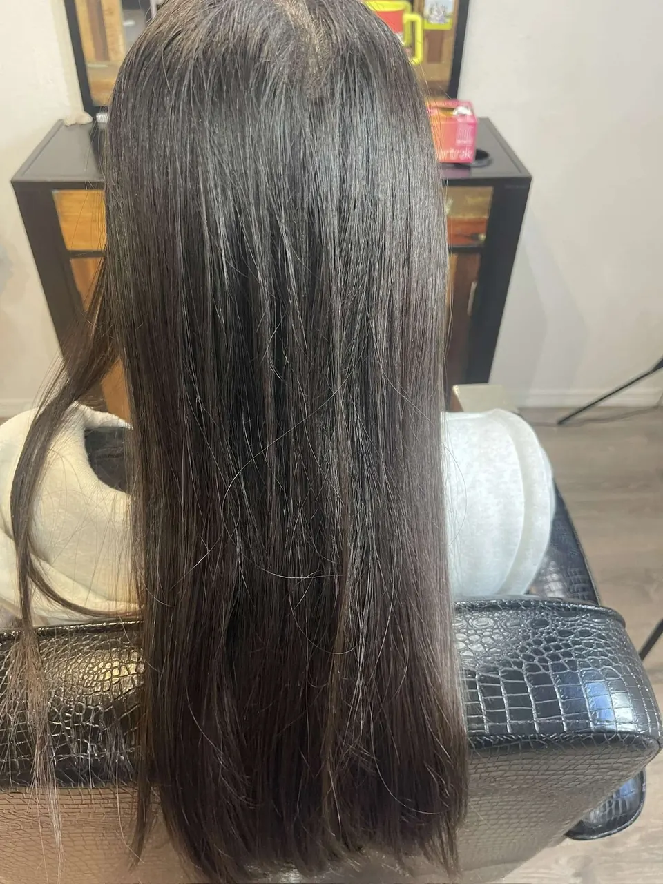 Long espresso-brown hair straightened to a mirror finish.