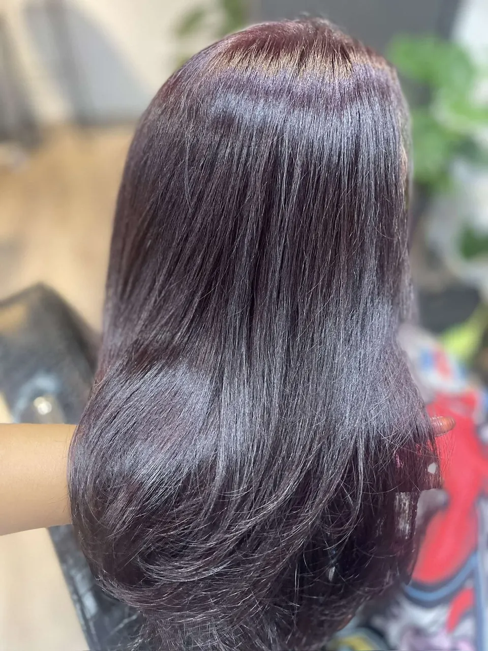 A deep plum gloss on long straightened layers.