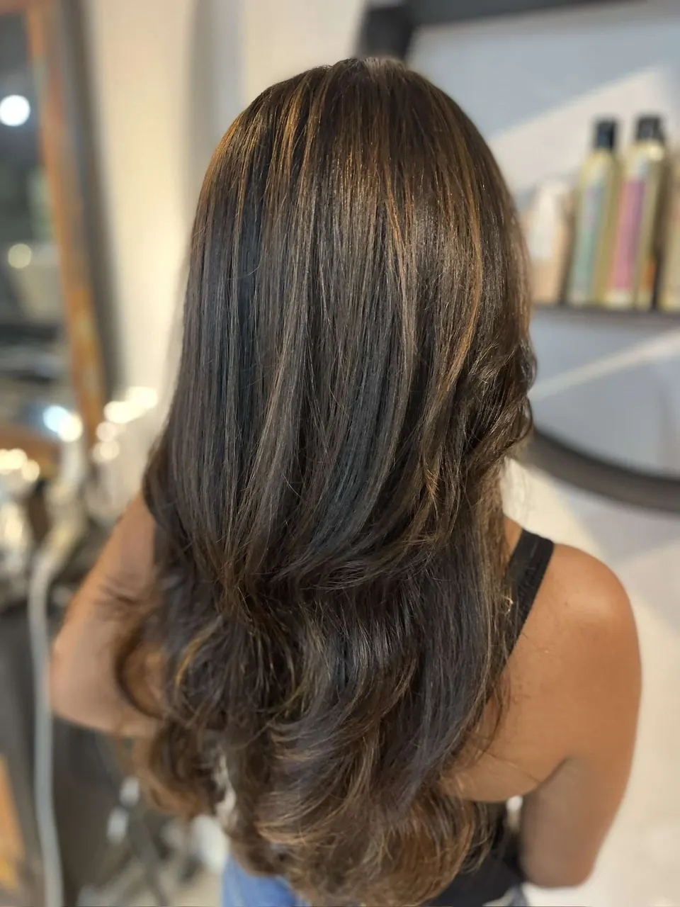 Rich brunette hair with subtle warmth through the layers.
