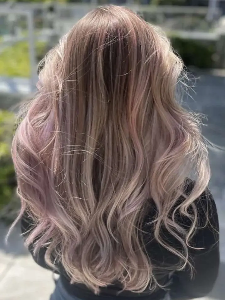 Rose and lilac balayage melting through pearl-blonde waves.