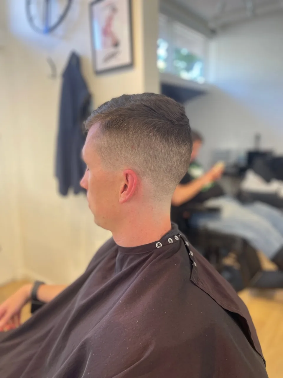 A clean skin fade blending into longer hair on top.
